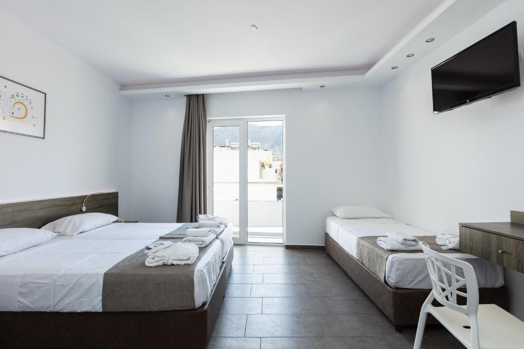 Mūsdienīgs viesnīcas numurs ar divām gultām, televizoru un piekļuvi balkonam, kas piedāvā skaistu skatu. Interjers ir gaišs un elegants, radot komfortablu atmosfēru.