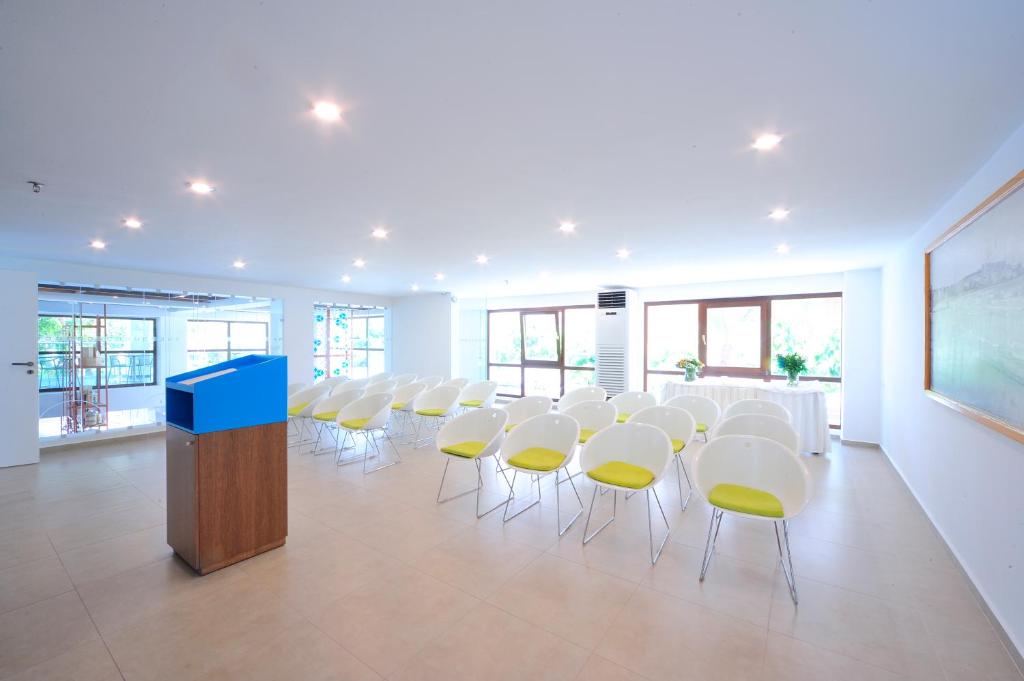 Mūsdienīgs konferenču zāle Atrium Ambiance Hotel ar gaišām krēsliem.