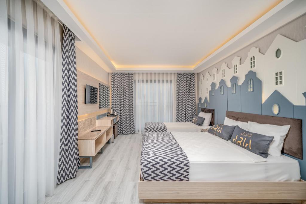 Numuri Aria Resort & Spa Hotel ar modernu interjeru un divām gultām.