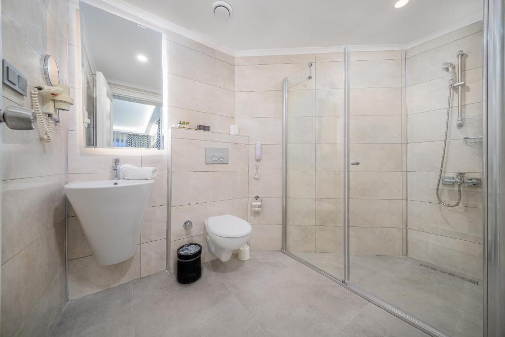 Mūsdienīgs vannasistaba Aria Resort & Spa Hotel ar dušu un elegantiem akcentiem.