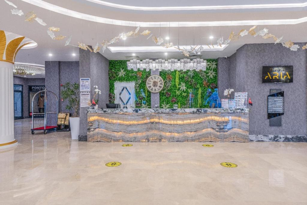 Reģistratūra Aria Resort & Spa Hotel ar zaļumiem un modernu dizainu.