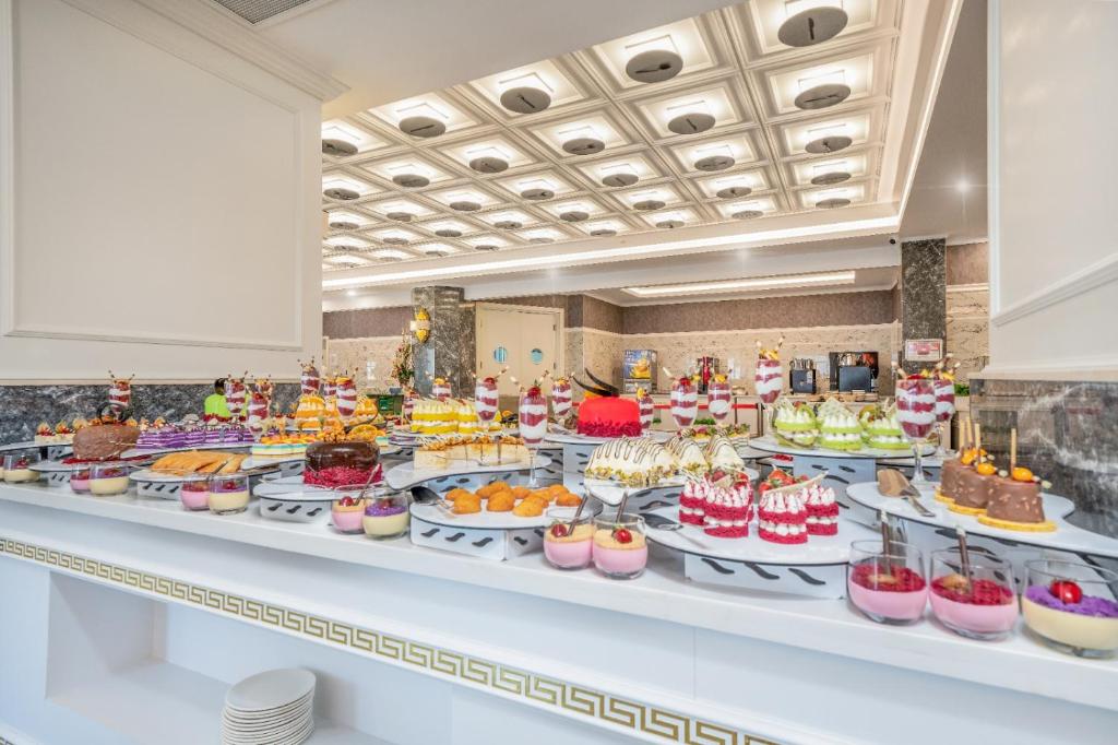Saldumu galdu ar dažādām kūkām un desertiem Aria Resort & Spa Hotel