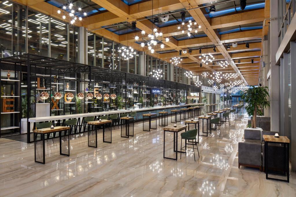 Moderna restorāna iekārtojums viesnīcā Nirvana Cosmopolitan ar elegantu apgaismojumu.