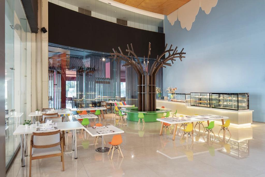 Mūsdienīgs restorāns ar krāsainām mēbelēm viesnīcā Nirvana Cosmopolitan