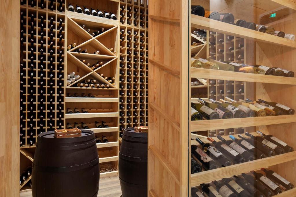 Vīna glabātuve Nirvana Cosmopolitan ar koka plauktiem un mucām.