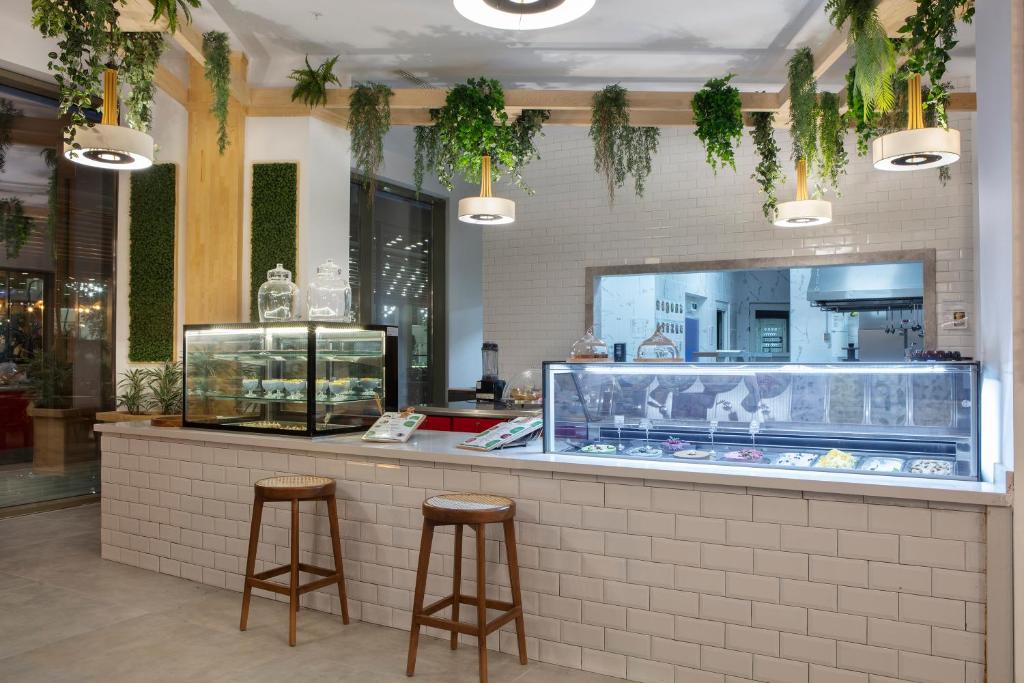 Kafijas stūris Nirvana Cosmopolitan ar augiem un saldējumu vitrīnām