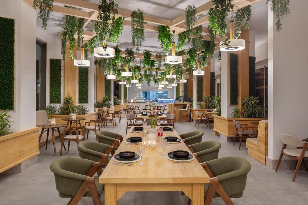 Mūsdienīgs restorāns Nirvana Cosmopolitan ar zaļiem augiem un kokšķiedras interjeru.