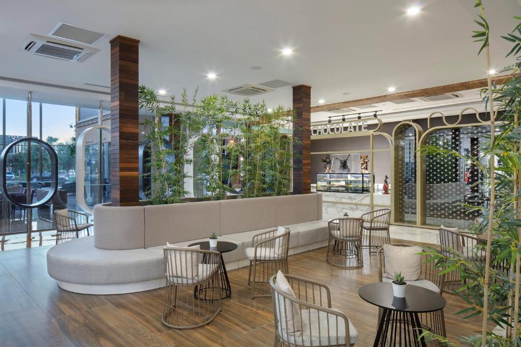 Moderns kafijas stūris Nirvana Cosmopolitan ar augiem un stilīgām mēbelēm.