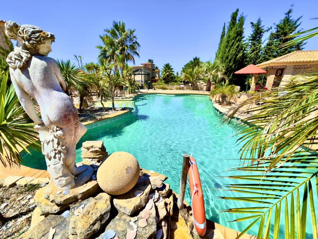 Quinta do Mar Country & Sea Village baseins ar skulptūru un palmām