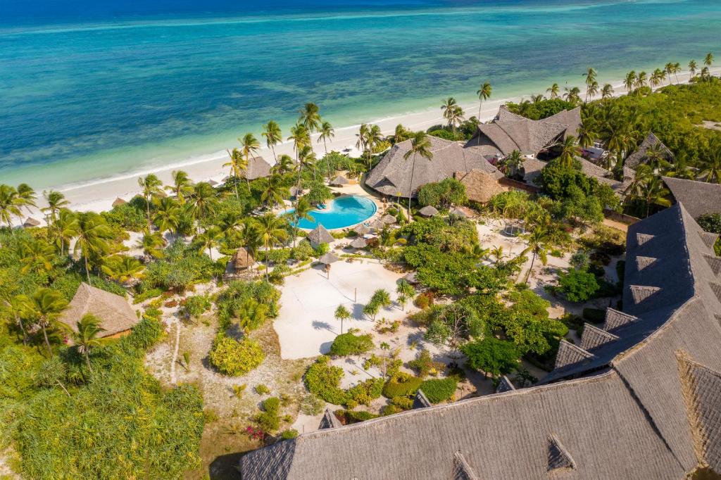 Zanzibar Queen viesnīca piekrastē ar baseinu un palmu dārzu.