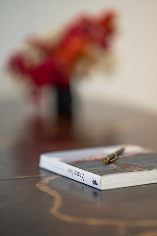 Galda dekors ar ziediem un grāmatu The One Resort Zanzibar.