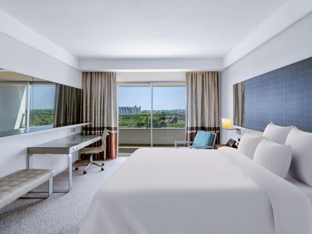 Gaišs un moderns numurs viesnīcā Rixos Premium Belek ar skatu uz dabu.