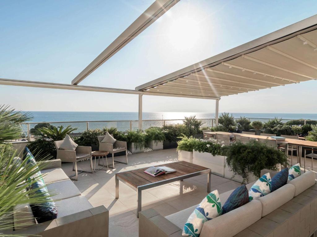 Rixos Premium Belek terase ar skatu uz jūru un ērtām mēbelēm.
