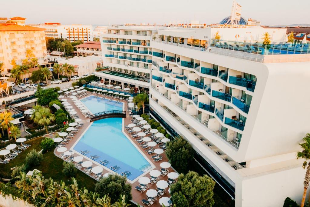 Selene Beach and Spa Hotel moderno viesnīca ar baseinu un saules krēsliem piekrastē.