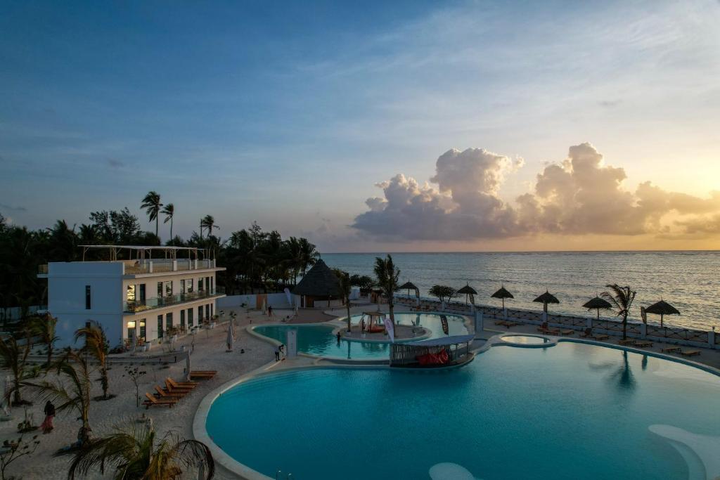 Saulriets pie baseina The One Resort Zanzibar piekrastē.