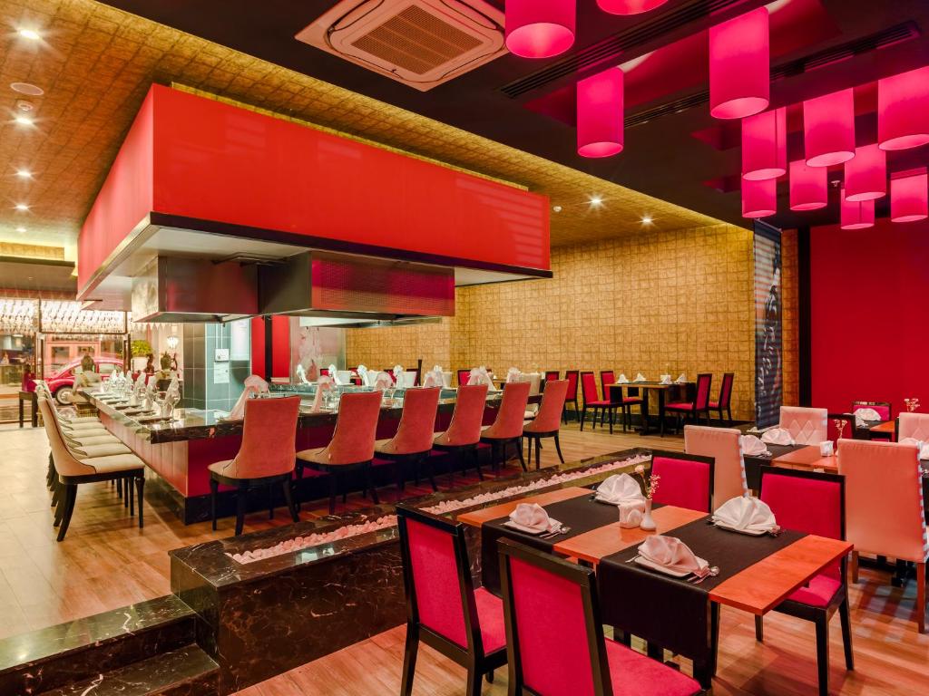 Moderns restorāns viesnīcā Magic Life Jacaranda ar sarkanu apgaismojumu.