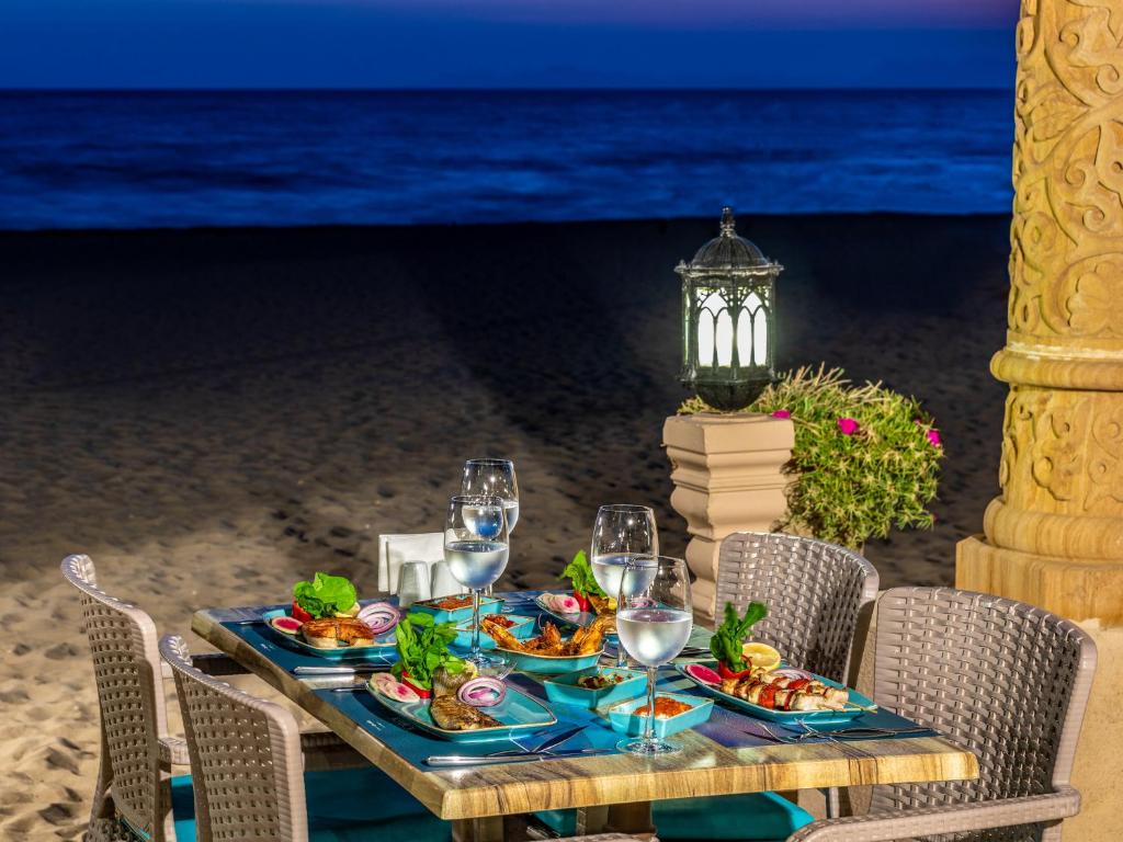 Romantiska vakariņas pie Spice Hotel & Spa pludmales, pie galds ar ēdieniem.