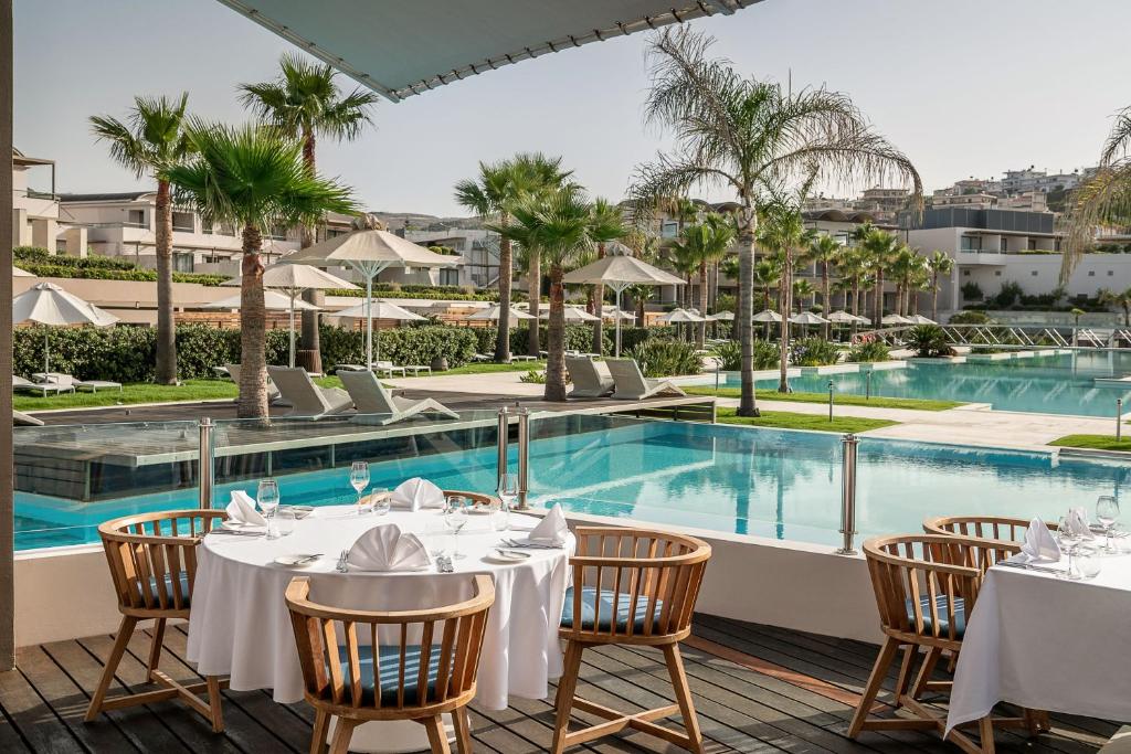 Elegants restorāns ar skatu uz baseinu un palmu dārzu, kas rada relaksējošu atmosfēru. Ideāla vieta, kur izbaudīt maltīti brīvā dabā.