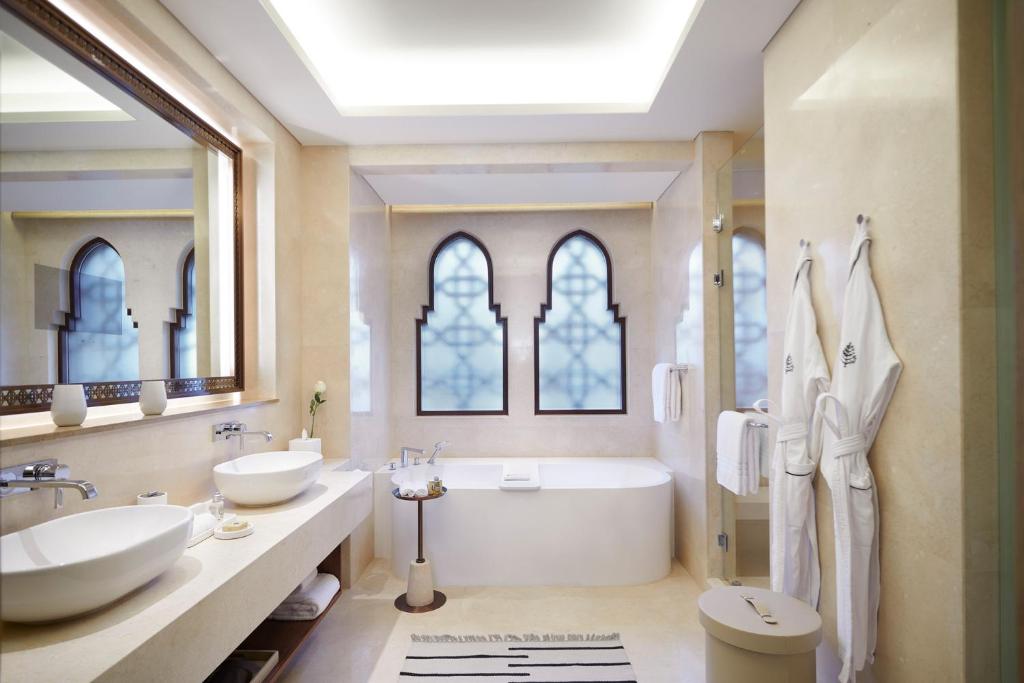 Plaša marmora vannas istaba ar divām izlietnēm un dziļu vannu Four Seasons Resort Sharm El Sheikh numurā.