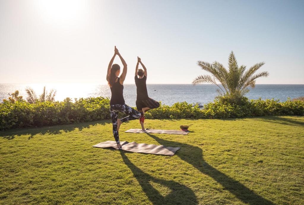 Rīta joga zālienā ar skatu uz jūru Four Seasons Resort Sharm El Sheikh teritorijā