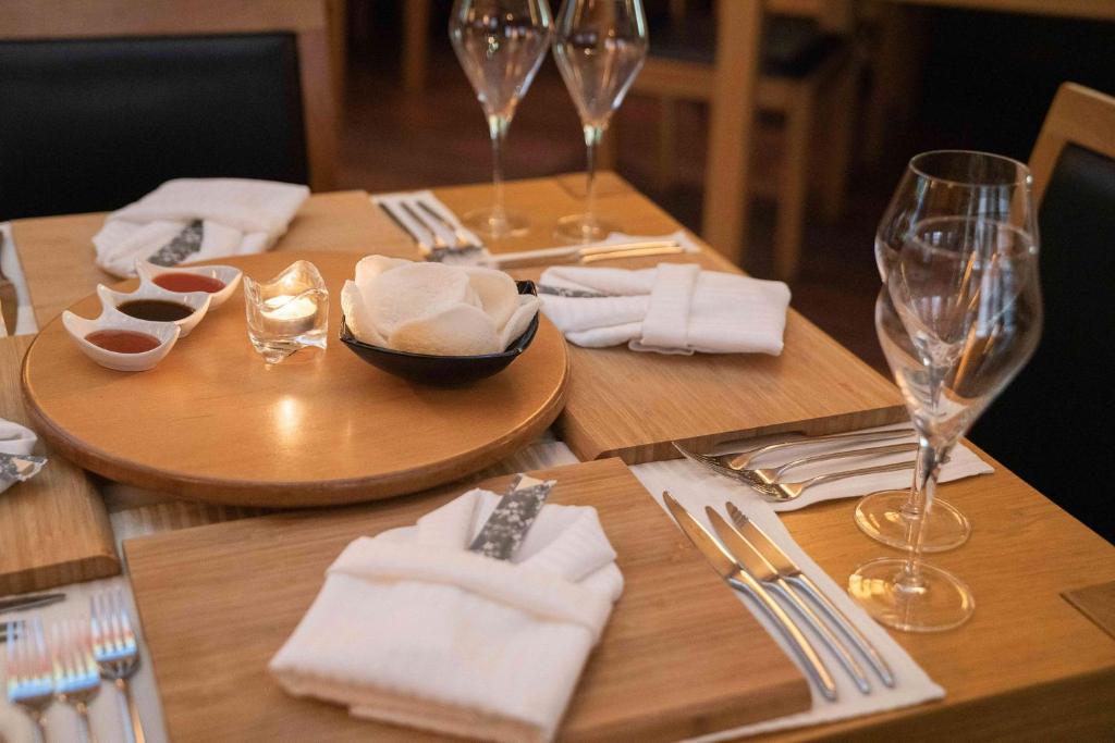 Labi sakārtota galda uzstādīšana ar novietotiem šķīvjiem, glāzēm un ēdieniem, tostarp maziem mērču traukiem un sveci. Ieteicams romantiskām vakariņām.