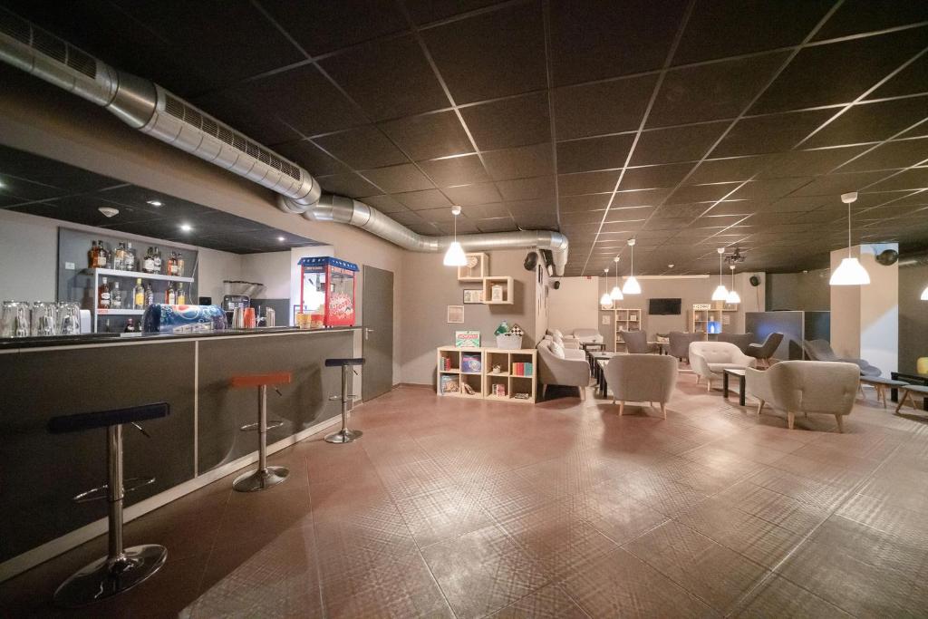 Mūsdienīga bāra un atpūtas telpa ar elegantiem dīvāniem un bāra letēm, kurā ir pieejami dzērieni un izklaide. Telpa ir apgaismota ar stilīgām lampām un piedāvā relaksējošu atmosfēru.