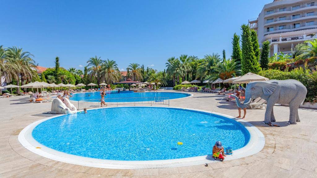 Starlight Resort baseins ar bērniem un palmām apkārt