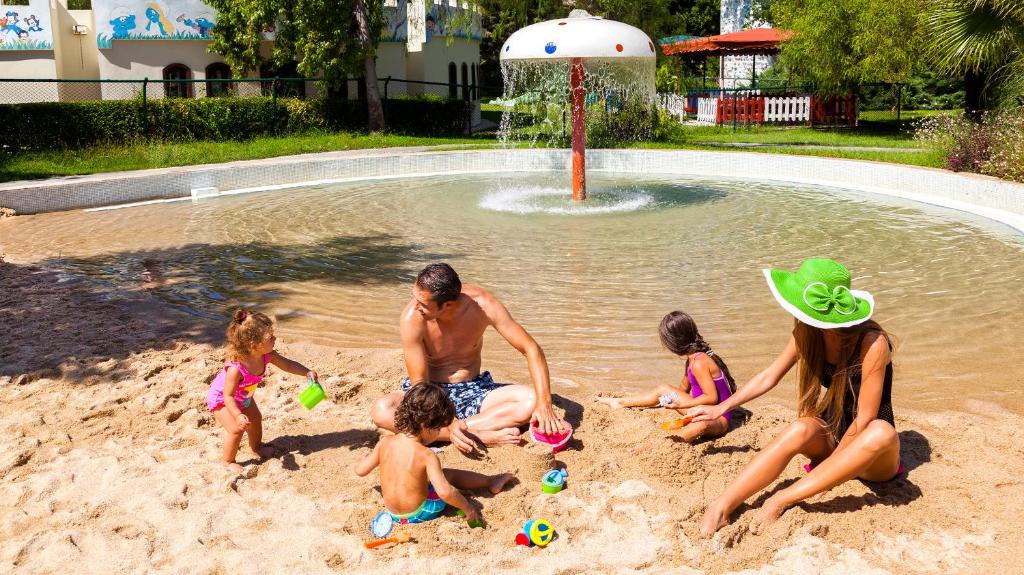 Bērni spēlējas smiltīs pie Starlight Resort ūdens atrakcijām.