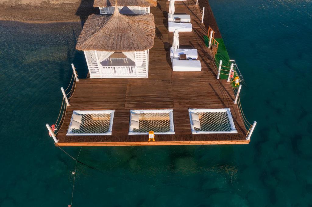 Viesnīcas Corendon Playa Kemer atpūtas terase piekrastē ar saulessargiem.