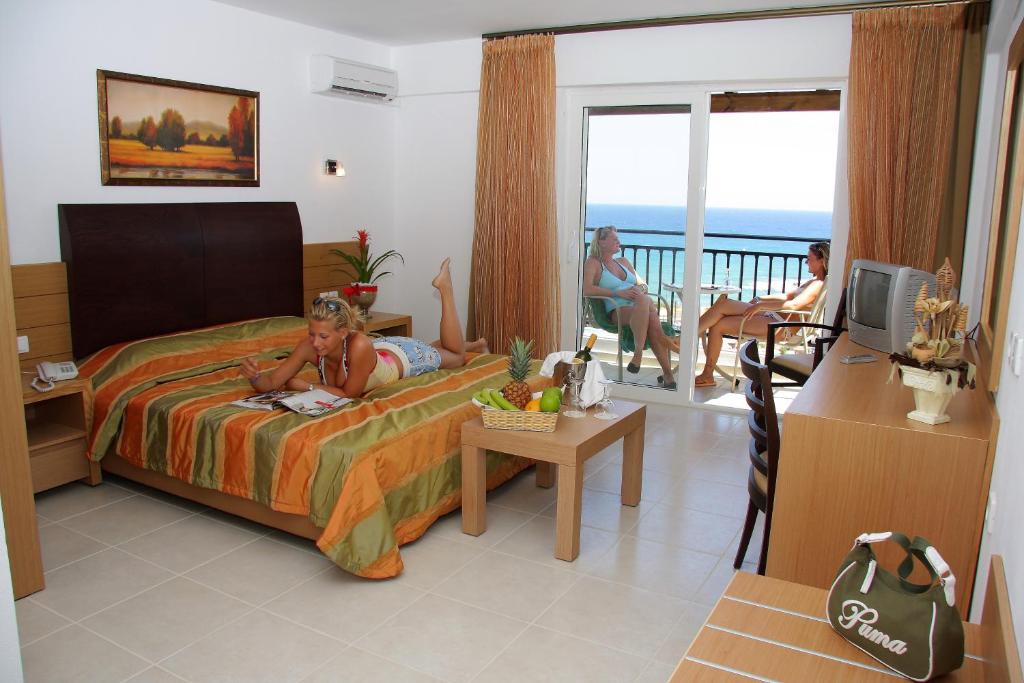 Mediterraneo Hotel numurs ar skatu uz jūru un viesiem uz balkona