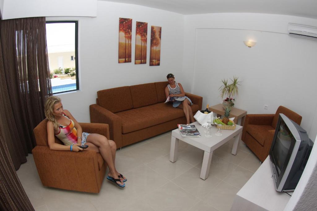 Mūsdienīgs viesnīcas numurs Mediterraneo Hotel ar divām viesēm atpūtas zonā.