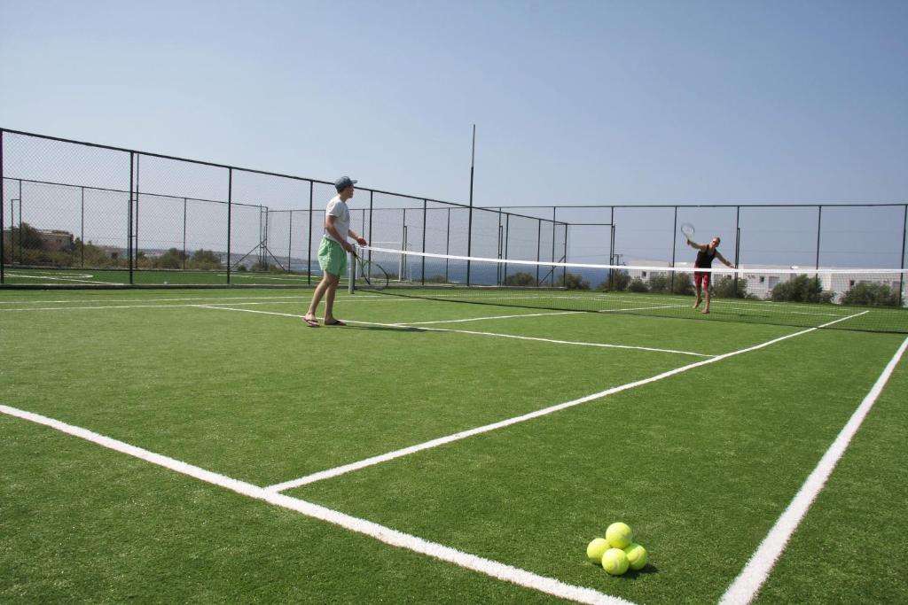 Tennis spēle Mediterraneo Hotel piekrastē ar zaļo laukumu un saulainu laiku.