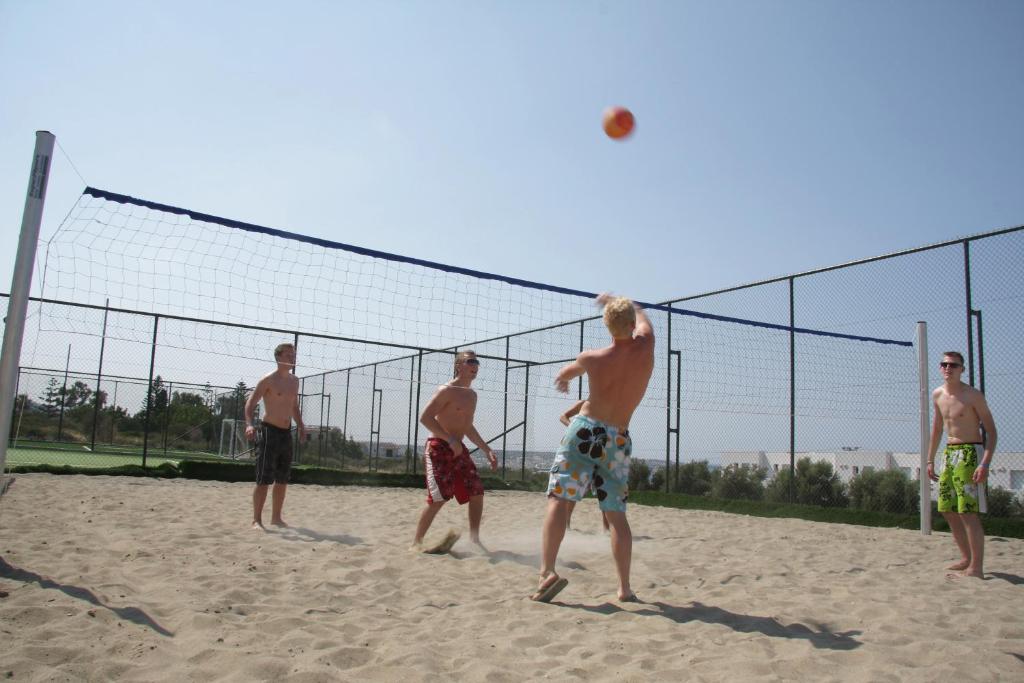 Vīrieši spēlē pludmales volejbolu pie Mediterraneo Hotel