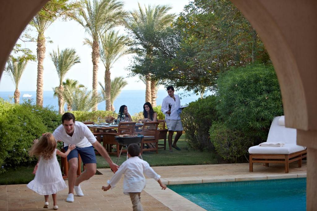 Tēvs spēlējas ar bērniem pie privātā baseina Four Seasons Resort Sharm El Sheikh.