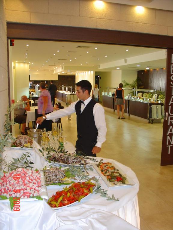 Bufete ar dažādiem ēdieniem, ko pasniedz viesmīlis elegantā apģērbā. Restorāna interjers ir mūsdienīgs un gaišs, radot patīkamu atmosfēru.