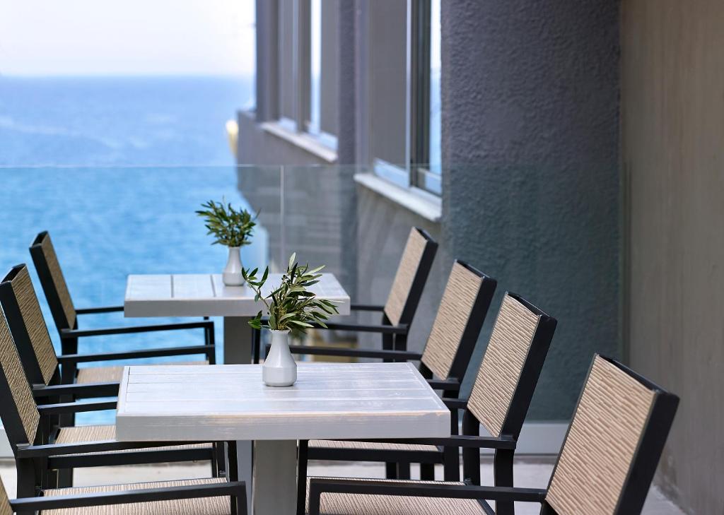 Mistral Bay Hotel terase ar skatu uz jūru un elegantiem galdiem.