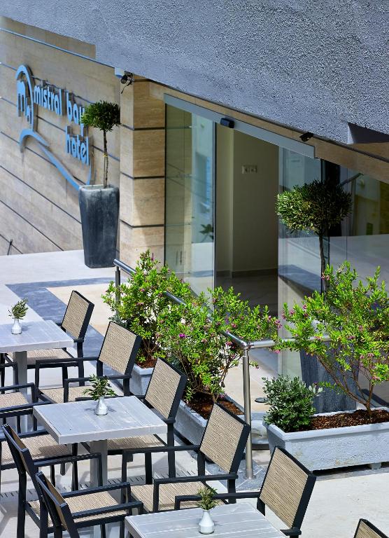 Mistral Bay Hotel ieeja ar terasi un dekoratīviem augiem.