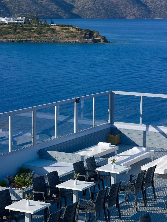 Mistral Bay Hotel terase ar skatu uz jūru un galdiem.