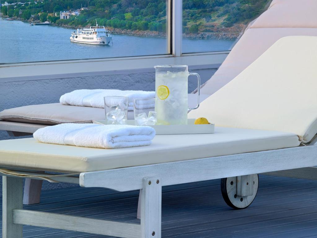 Atpūtas krēsli pie Mistral Bay Hotel ar skatu uz jūru un atsvaidzinošu dzērienu.