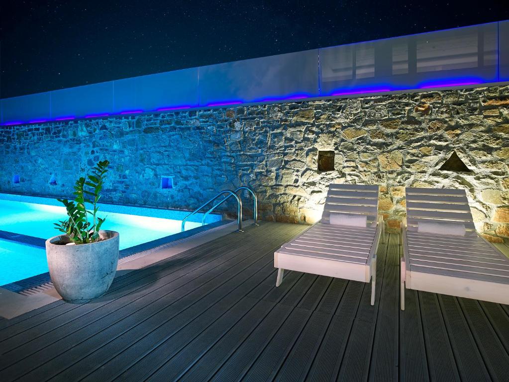 Mistral Bay Hotel baseins ar sauļošanās krēsliem piekrastē naktī
