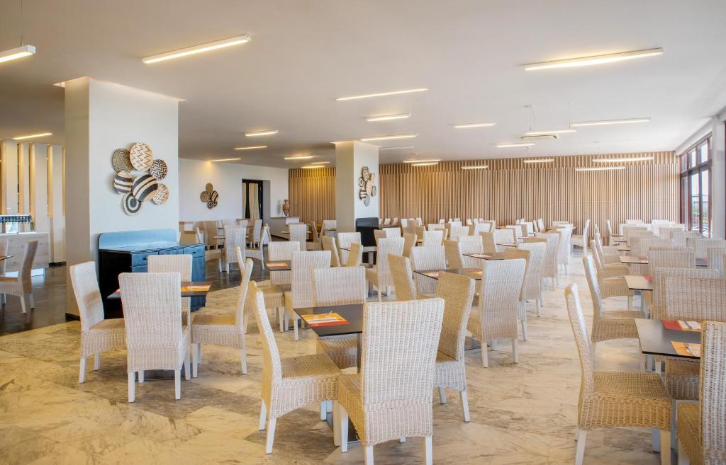 Gaišs un moderns restorāns Sol Marina Beach Crete ar ērtām ratanu mēbelēm.