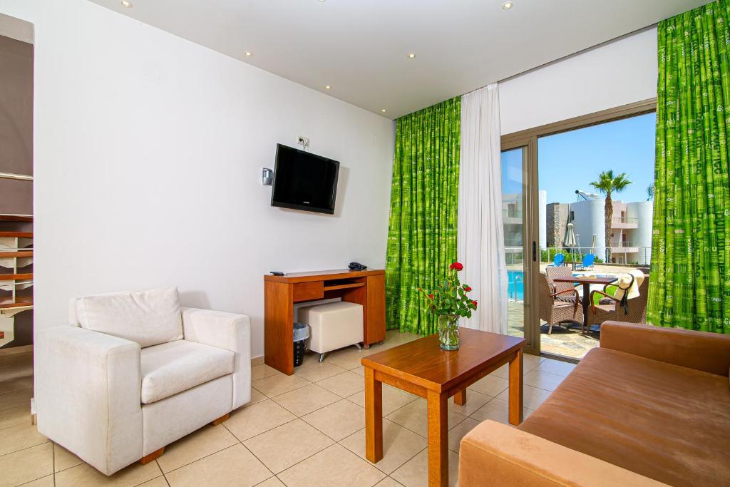 Mūsdienīgs viesnīcas numurs ar zaļām aizkariem, ērtām mēbelēm un skatu uz baseinu. Interjers ir gaišs un viesmīlīgs, radot relaksējošu atmosfēru.