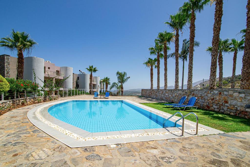 Baseins ar palmām un sauļošanās krēsliem skaistā ainavā. Ideāla vieta atpūtai un relaksācijai.