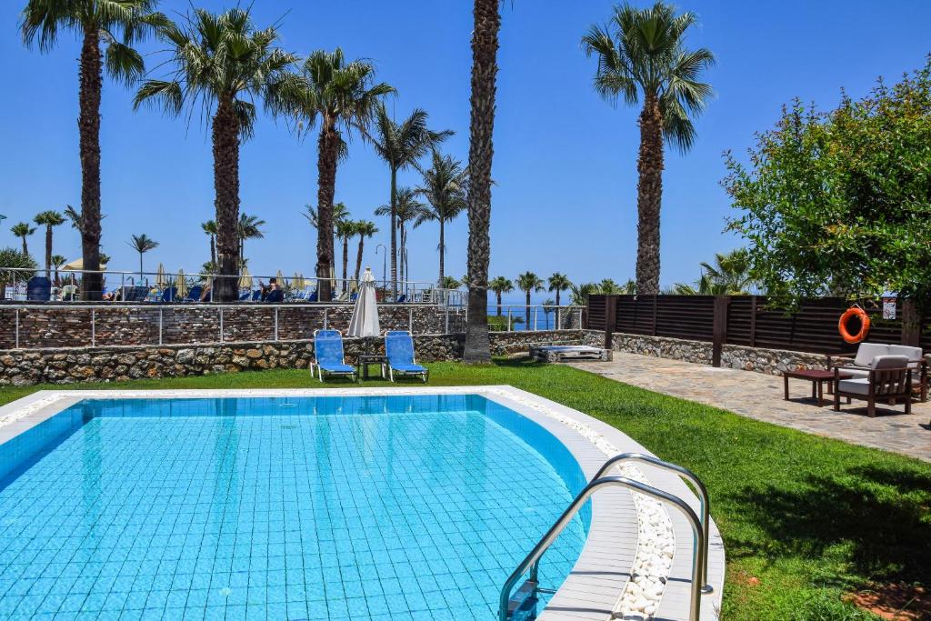 Lieliska peldbaseina ar palmām un saulainu debesu fonu, kas rada atpūtas un relaksācijas sajūtu. Ideāla vieta atpūtai un brīvā laika pavadīšanai.