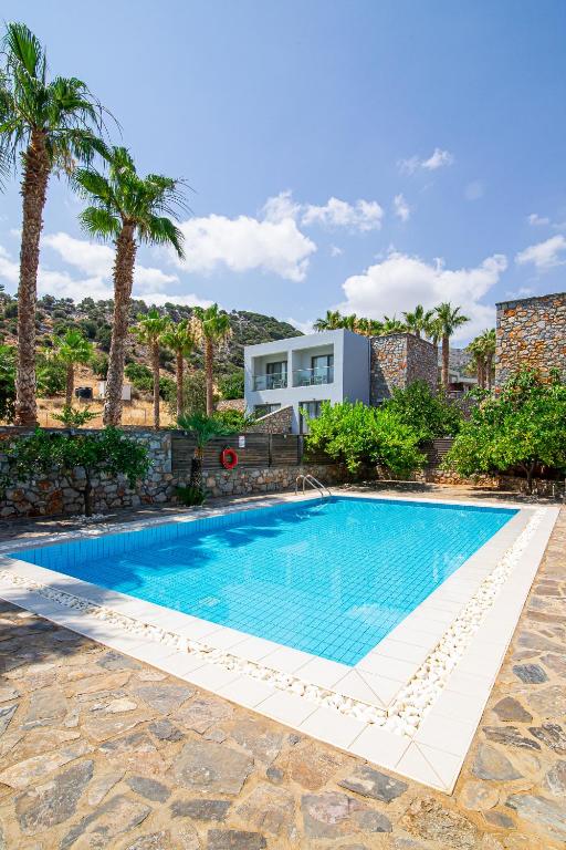 Moderns peldbaseins ar skaidru zilu ūdeni, ierāmēts ar baltām flīzēm un akmens apmali, apkārt palmām un mūsdienīgām ēkām. Ideāla vieta atpūtai un relaksācijai.