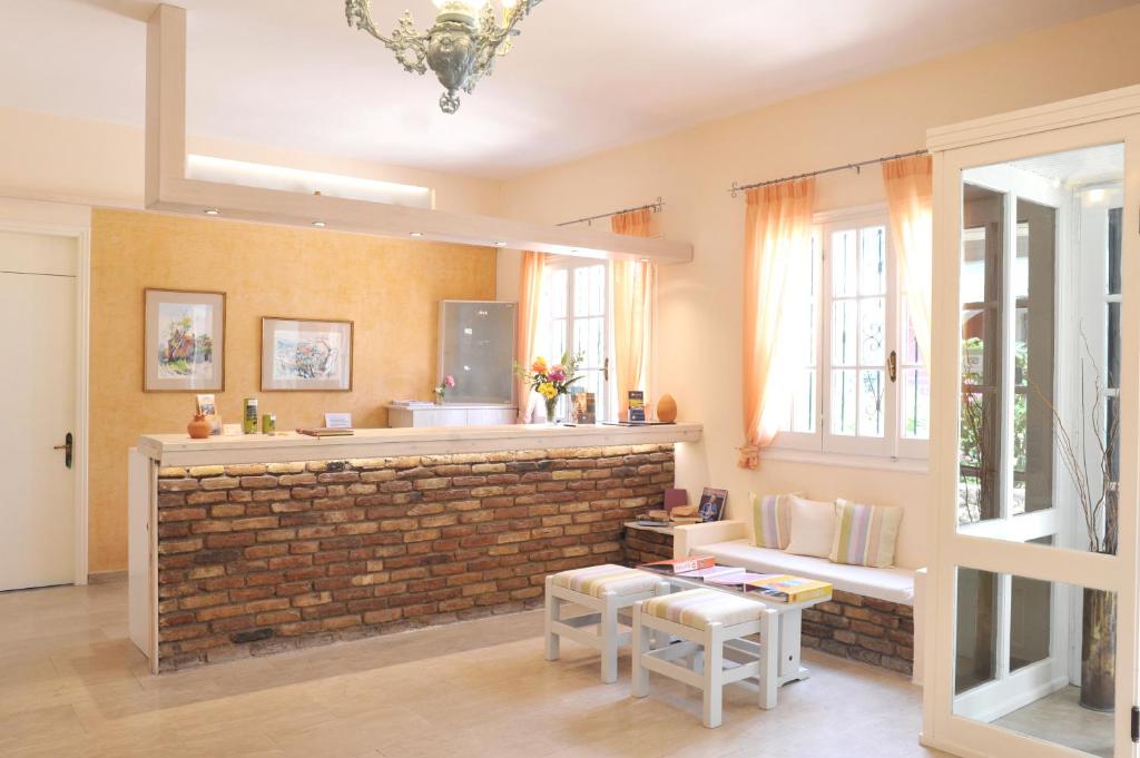 Mūsdienīgs viesnīcas reģistratūras interjers ar ķieģeļu akcentiem, gaišām krāsām un dabīgu apgaismojumu, kas rada siltu un viesmīlīgu atmosfēru.