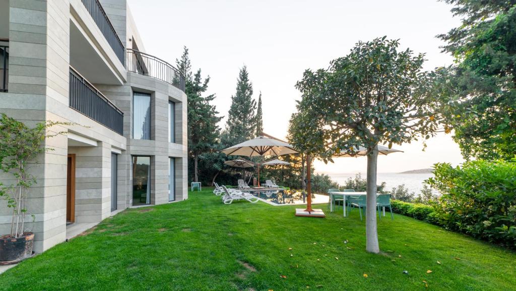 Duja Bodrum viesnīcas dārzs ar saulessargiem un peldbaseinu piekrastē