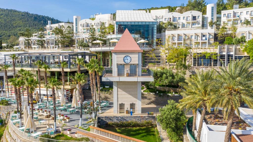Skats uz Duja Bodrum viesnīcu ar pulksteni un palmu koku alejām.