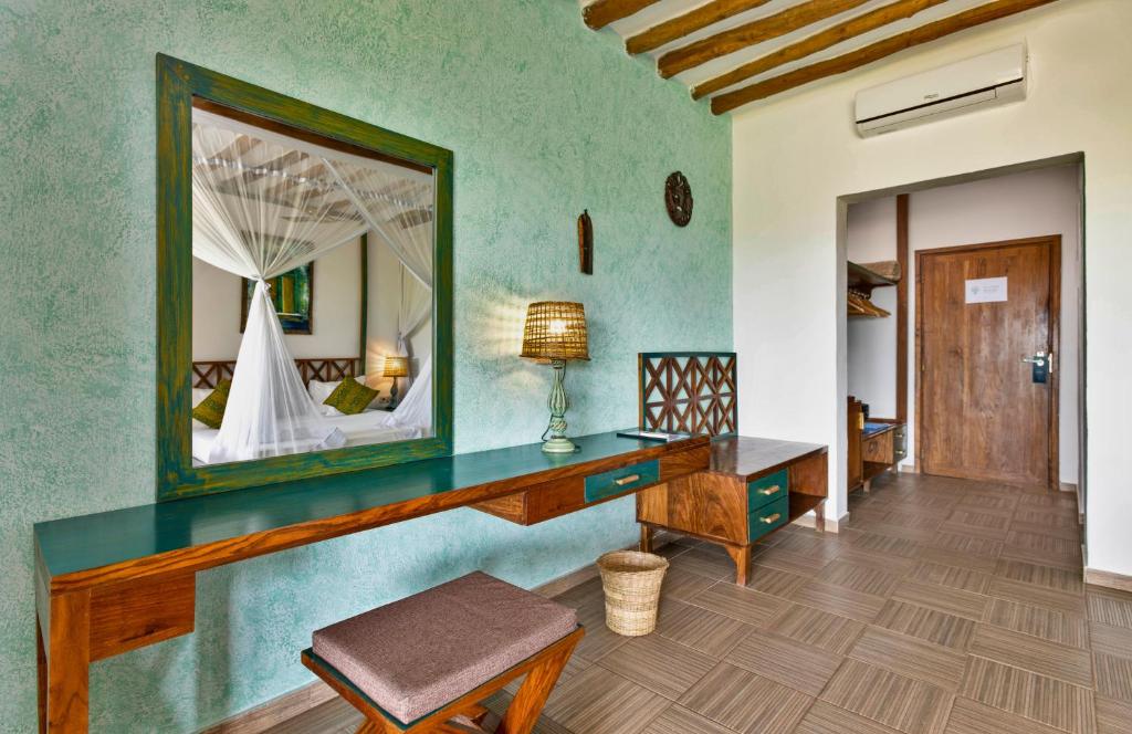 Zanzibar Queen numurs ar elegantu interjeru un koka mēbelēm.