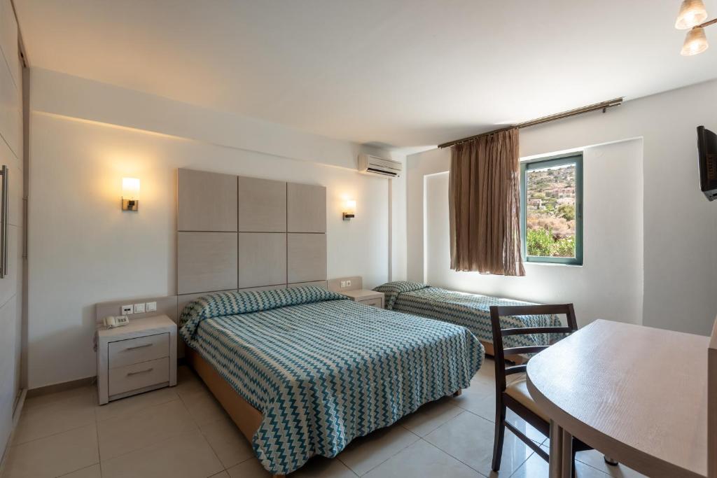 Mūsdienīgs numurs Mediterraneo Hotel ar divām gultām un logu uz dabu.